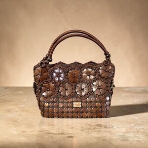 Handmade coconut shell floral handbag with braided handles and wooden tag.